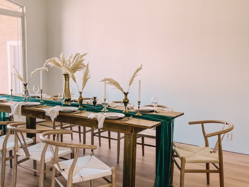 Wooden farm table with an emerald runner, pampas grass and brass candlesticks